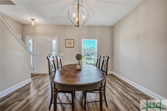 dining area with a chandelier, wood finished floors, and baseboards