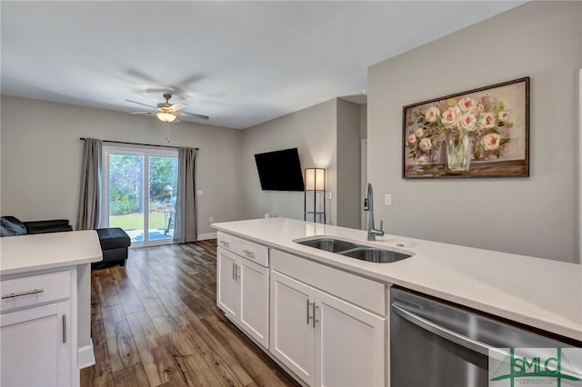 kitchen featuring dishwasher, open floor plan, wood finished floors, light countertops, and a sink