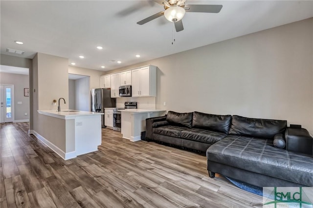 living room featuring baseboards, wood finished floors, visible vents, and recessed lighting