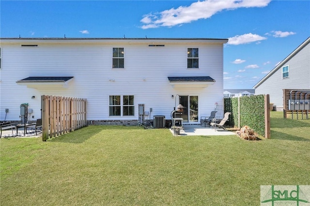 back of property with a patio, a yard, central AC, and fence