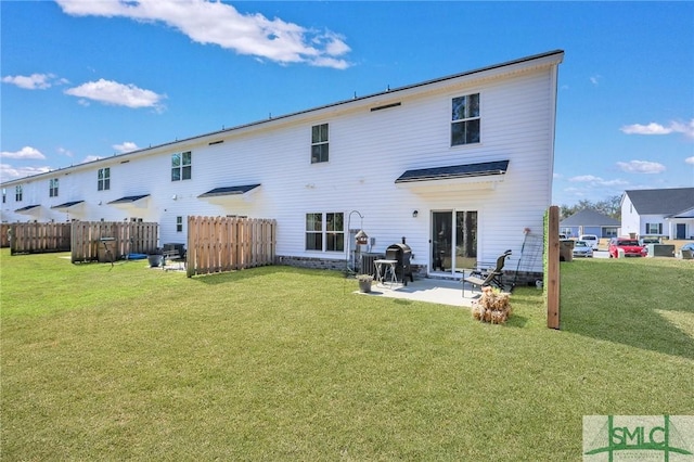 back of property featuring a patio, a lawn, and fence