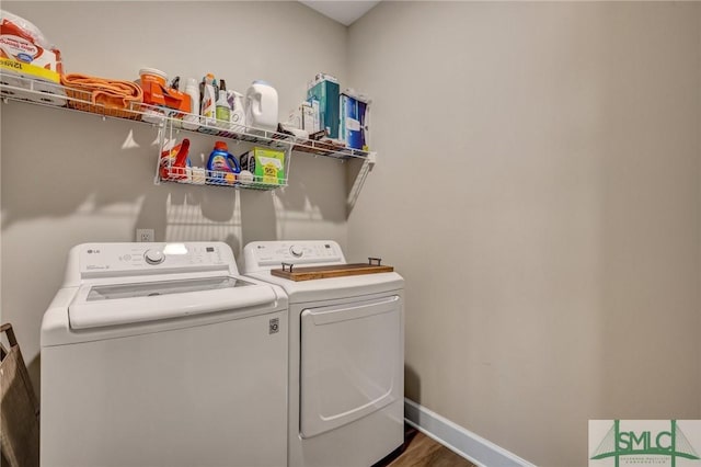 laundry area featuring laundry area, separate washer and dryer, wood finished floors, and baseboards