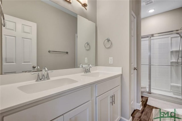 bathroom featuring visible vents, a sink, toilet, and double vanity