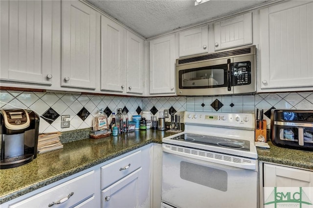 kitchen featuring white range with electric cooktop, stainless steel microwave, decorative backsplash, a textured ceiling, and dark stone counters