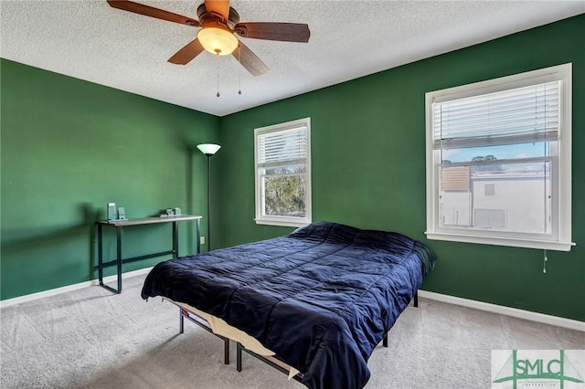 carpeted bedroom featuring a ceiling fan, baseboards, and a textured ceiling