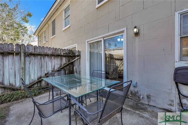 view of patio with outdoor dining area and fence