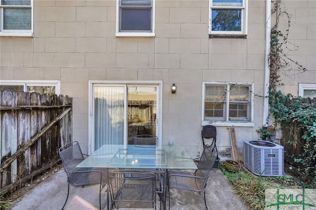 view of patio featuring central air condition unit, fence, and outdoor dining space