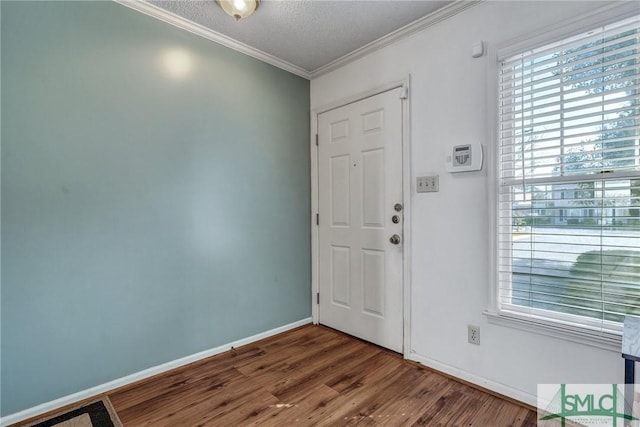 entrance foyer with crown molding, a textured ceiling, baseboards, and wood finished floors