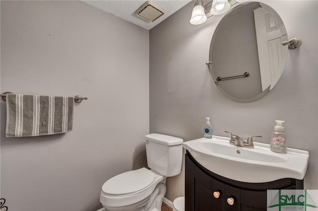 bathroom featuring visible vents, vanity, and toilet