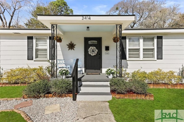 view of exterior entry with a yard