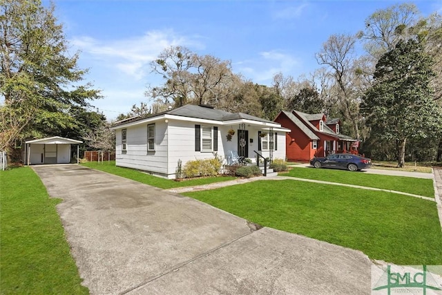 view of front of property with an outbuilding, a detached garage, fence, a carport, and a front lawn