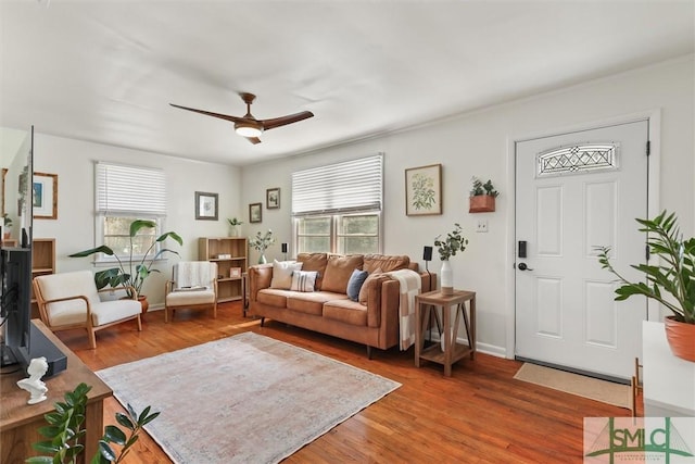 living area with ceiling fan, wood finished floors, and baseboards