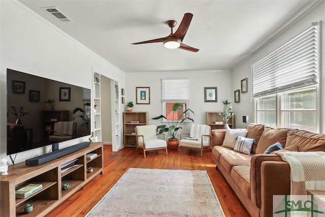 living room featuring ceiling fan, light wood-type flooring, and visible vents