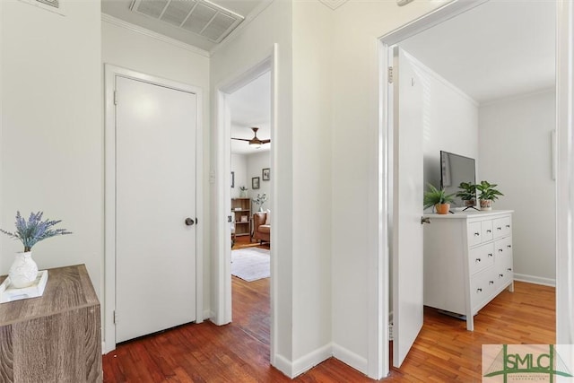 corridor with ornamental molding, visible vents, and light wood-style flooring