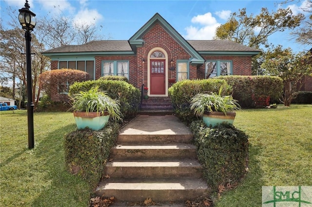 view of front of property featuring a front yard and brick siding