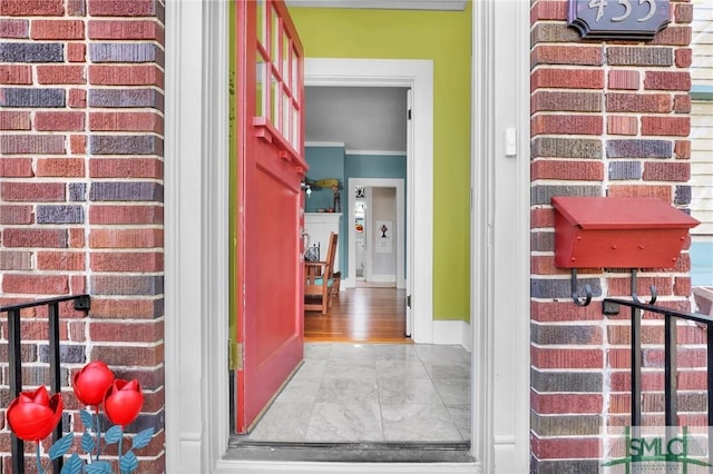 view of exterior entry featuring brick siding