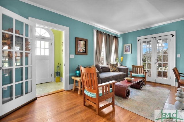 living area with baseboards, french doors, wood finished floors, and crown molding