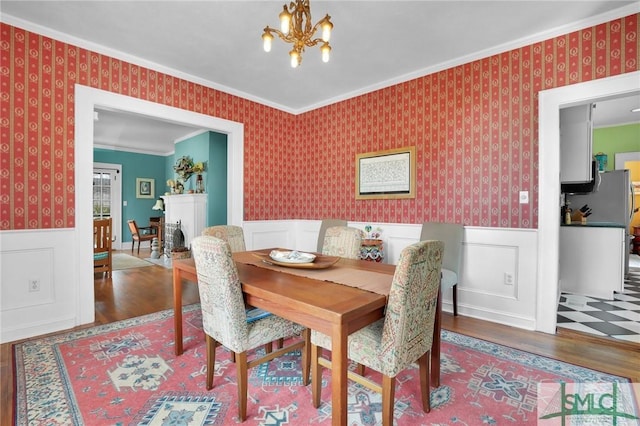 dining space featuring wainscoting and wallpapered walls