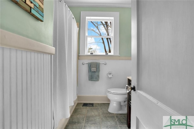 bathroom with baseboards, visible vents, a shower with shower curtain, toilet, and vanity