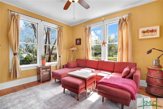 sitting room with ceiling fan, wood finished floors, and baseboards