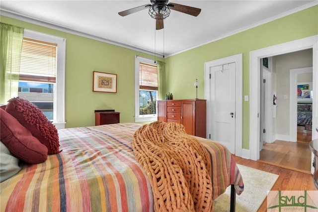 bedroom with baseboards, ceiling fan, ornamental molding, and wood finished floors