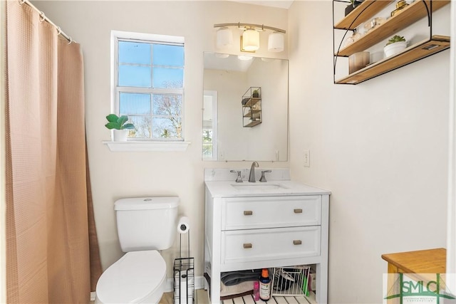 bathroom with vanity, a shower with shower curtain, and toilet