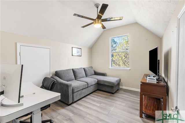 office space featuring light wood finished floors, baseboards, ceiling fan, lofted ceiling, and a textured ceiling