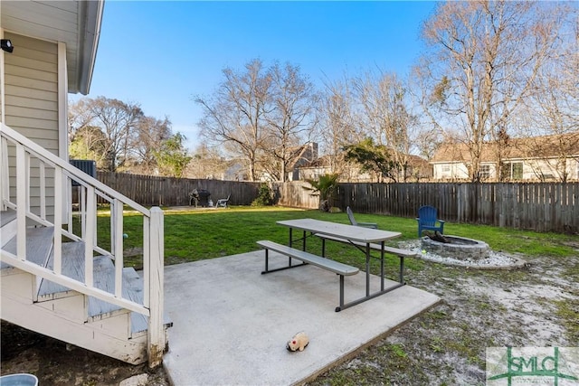 view of yard with stairs, a patio area, a fenced backyard, and an outdoor fire pit