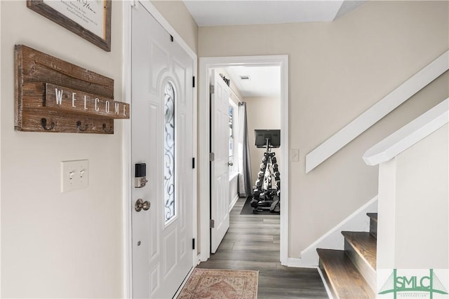 foyer entrance featuring stairway, baseboards, and wood finished floors