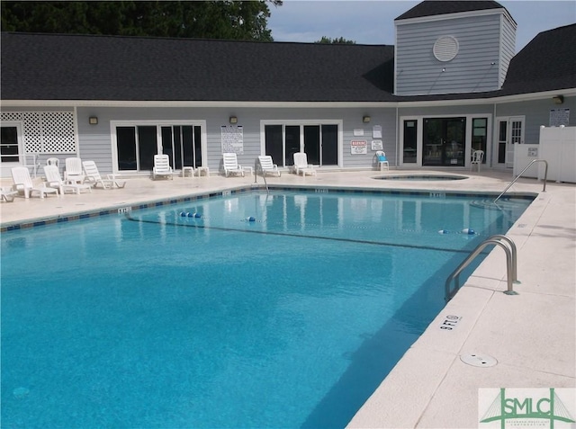 community pool with a community hot tub and a patio area