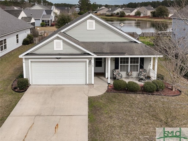 traditional-style home featuring covered porch, a water view, concrete driveway, a garage, and a residential view