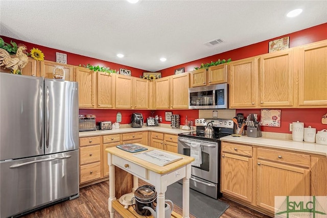 kitchen with stainless steel appliances, light countertops, visible vents, and dark wood-type flooring