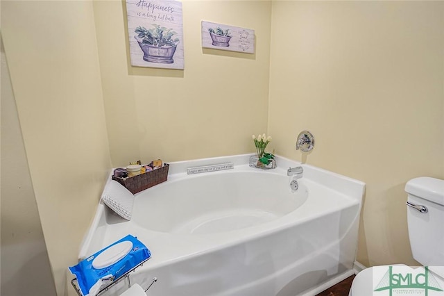 bathroom with a garden tub and toilet