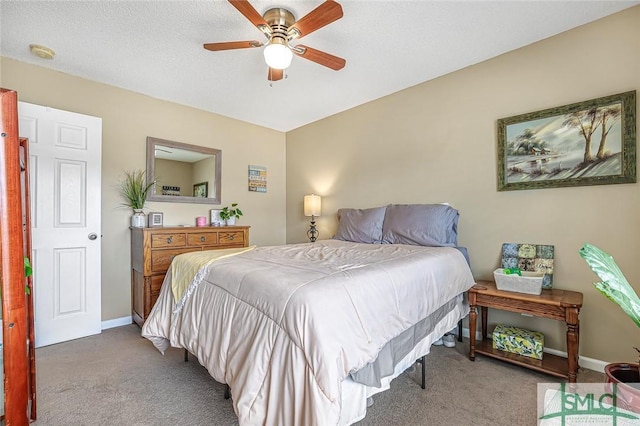 carpeted bedroom with a textured ceiling, baseboards, and a ceiling fan