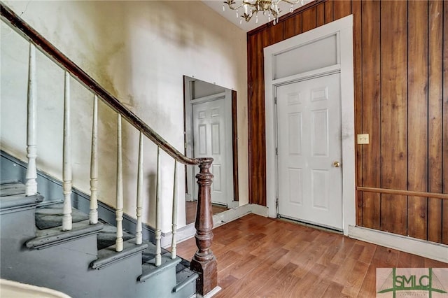 entryway with stairs, wood finished floors, and a chandelier