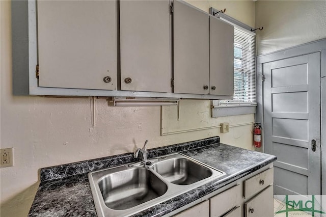 kitchen featuring dark countertops and a sink