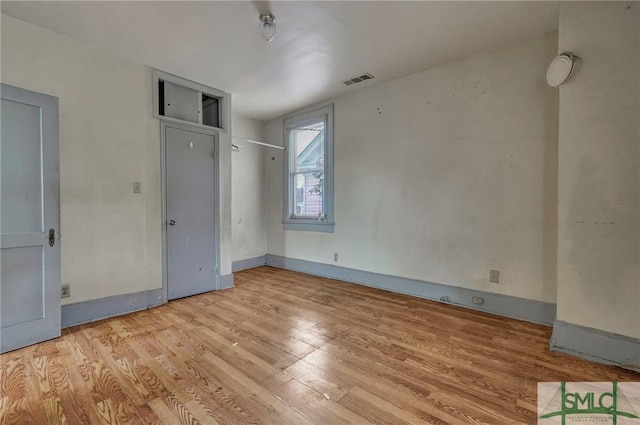 interior space with baseboards, visible vents, and wood finished floors