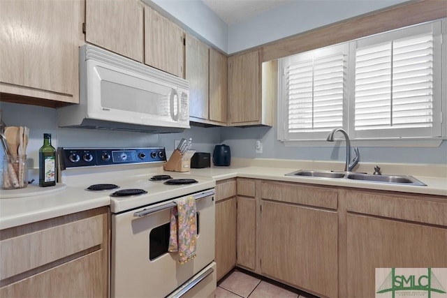 kitchen featuring light countertops, light brown cabinets, a sink, light tile patterned flooring, and white appliances