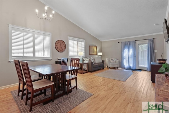 dining room featuring baseboards, ornamental molding, high vaulted ceiling, light wood-style floors, and a chandelier