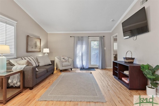 living room featuring light wood finished floors, visible vents, and crown molding