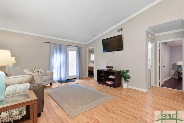 living room featuring crown molding, visible vents, vaulted ceiling, wood finished floors, and baseboards