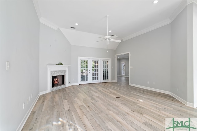 unfurnished living room featuring ornamental molding, light wood finished floors, a warm lit fireplace, and baseboards