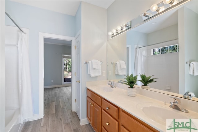 full bathroom featuring shower / bath combo, double vanity, a sink, and wood finished floors