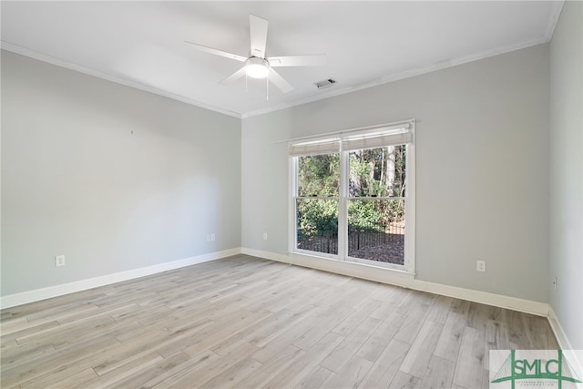 spare room featuring light wood finished floors, ornamental molding, visible vents, and baseboards