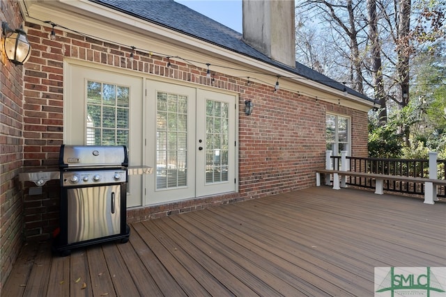 wooden deck featuring french doors and a grill