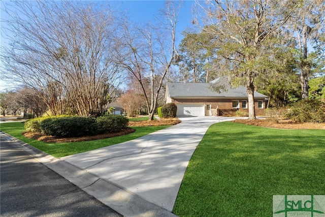 view of side of property with driveway, a lawn, and brick siding