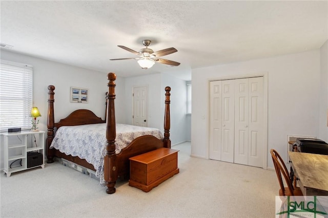 bedroom with a closet, carpet floors, a textured ceiling, and ceiling fan