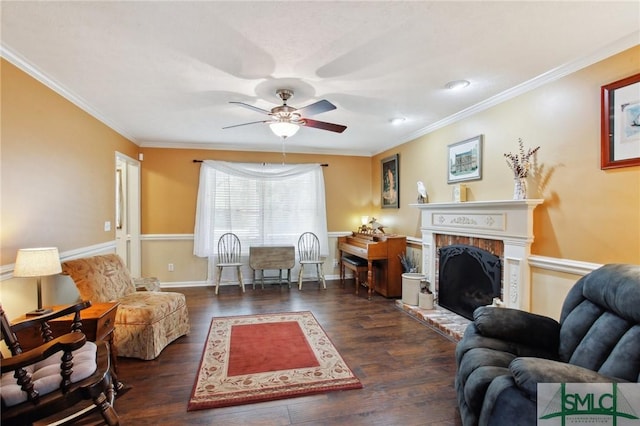 living room with a fireplace with raised hearth, wood finished floors, and ornamental molding