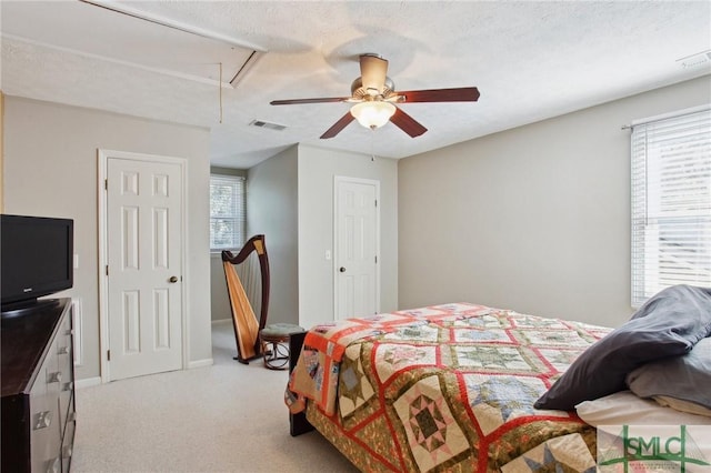 bedroom with attic access, multiple windows, visible vents, and light carpet