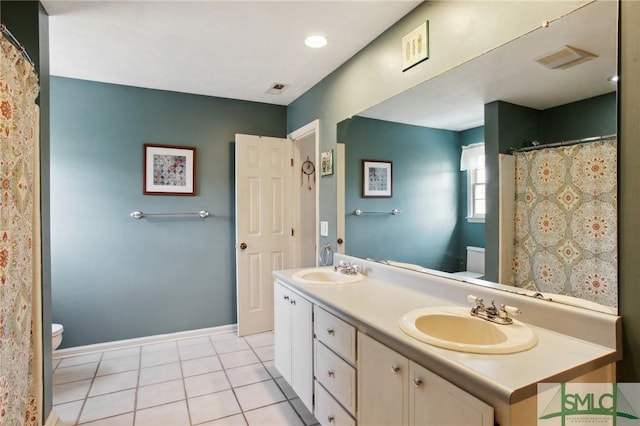 bathroom featuring tile patterned floors, toilet, and a sink